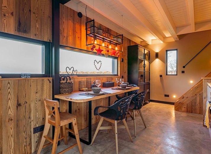 Gemuetliches Wohnzimmer von Spoelde wiel in Callantsoog mit Kamin und modernen Moebeln.