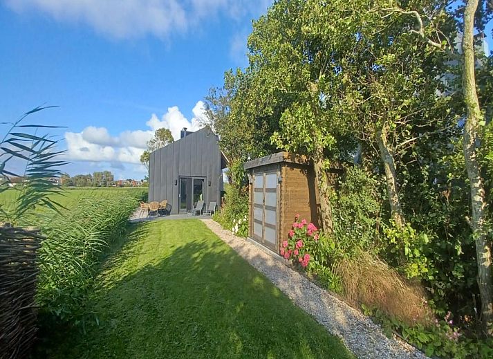 Helles Wohnzimmer von Spoelde wiel in Callantsoog mit Zugang zur Terrasse und natuerlichem Licht.