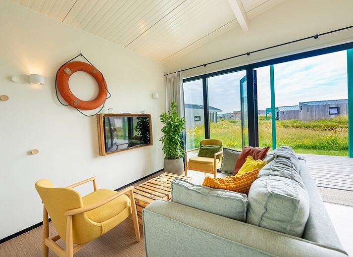 Aussenansicht des Ferienhauses Royal Dune 4 in Callantsoog mit grosser Veranda und natuerlicher Umgebung.