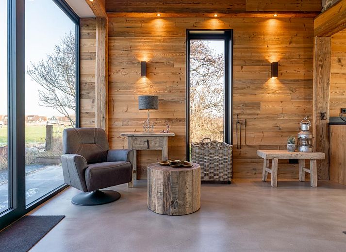 Seitenansicht des Ferienhauses De Bonte Specht mit gruenem Garten in Callantsoog, Nordholland.