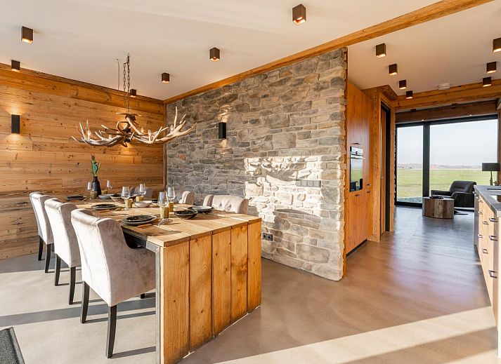 Seitenansicht des Ferienhauses De Bonte Specht mit gruenem Garten in Callantsoog, Nordholland.