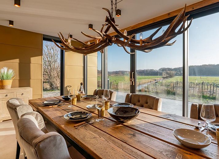 Seitenansicht des Ferienhauses De Bonte Specht mit gruenem Garten in Callantsoog, Nordholland.