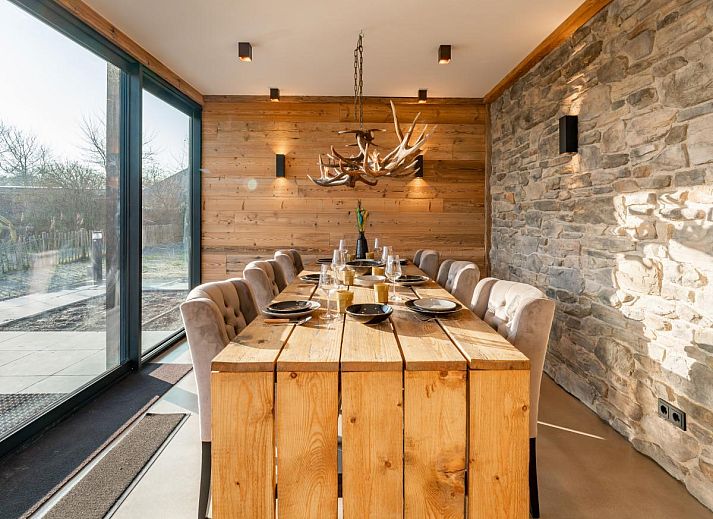 Seitenansicht des Ferienhauses De Bonte Specht mit gruenem Garten in Callantsoog, Nordholland.