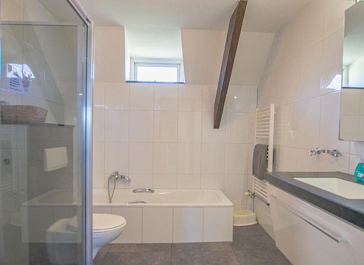 Gezellige eetkamer in Landhuis Duinzicht, een vakantiehuis in Callantsoog aan de Noordzeekust, Noord-Holland, met houten vloeren en moderne inrichting.