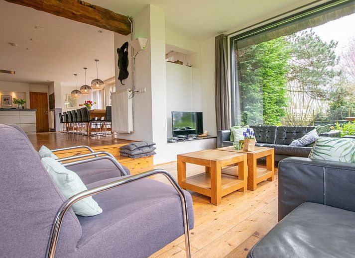 Gezellige eetkamer in Landhuis Duinzicht, een vakantiehuis in Callantsoog aan de Noordzeekust, Noord-Holland, met houten vloeren en moderne inrichting.