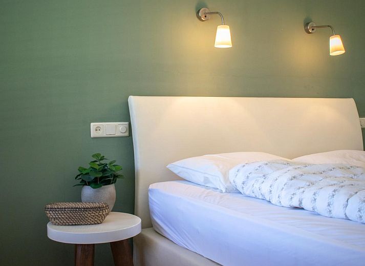 Gezellige eetkamer in Landhuis Duinzicht, een vakantiehuis in Callantsoog aan de Noordzeekust, Noord-Holland, met houten vloeren en moderne inrichting.