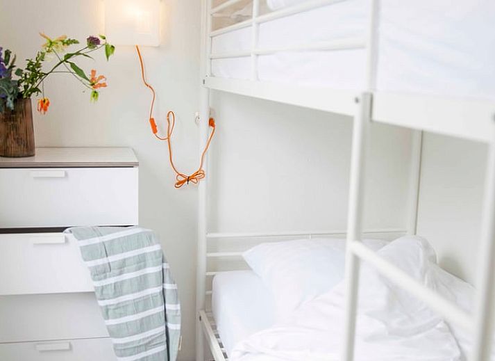 Esstisch im Ferienhaus in Callantsoog, Nordseekueste, Nordholland, mit frischem Brot und Blumen.