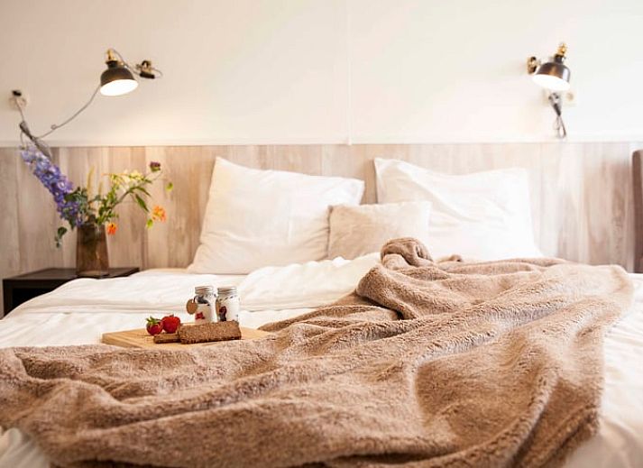 Sonnige Terrasse am Ferienhaus in Callantsoog, Nordseekueste, Nordholland, mit bequemen Sitzgelegenheiten.