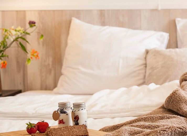 Sonnige Terrasse am Ferienhaus in Callantsoog, Nordseekueste, Nordholland, mit bequemen Sitzgelegenheiten.