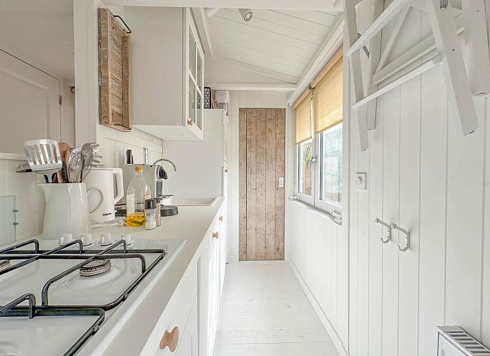 Gezellige woonkamer van vakantiehuis Sol in Callantsoog met comfortabele bank.