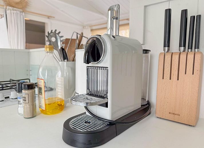 Gezellige woonkamer van vakantiehuis Sol in Callantsoog met comfortabele bank.