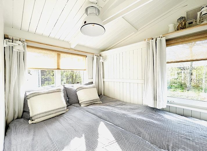 Gezellige woonkamer van vakantiehuis Sol in Callantsoog met comfortabele bank.