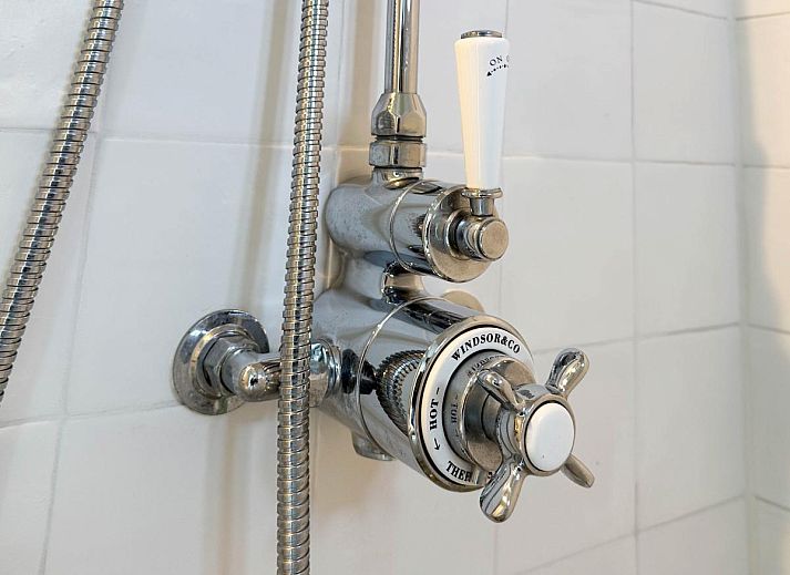 Lichte woonkamer van vakantiehuis Sol in Callantsoog met uitzicht op de tuin.