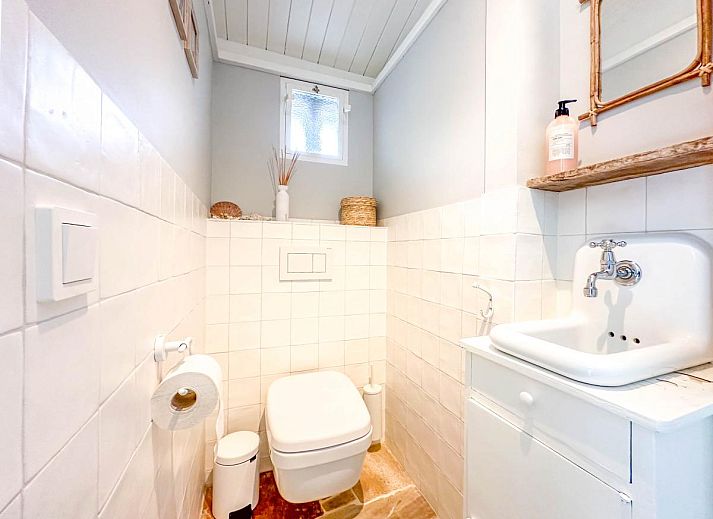 Stijlvolle woonkamer van vakantiehuis Sol in Callantsoog met veel natuurlijk licht.