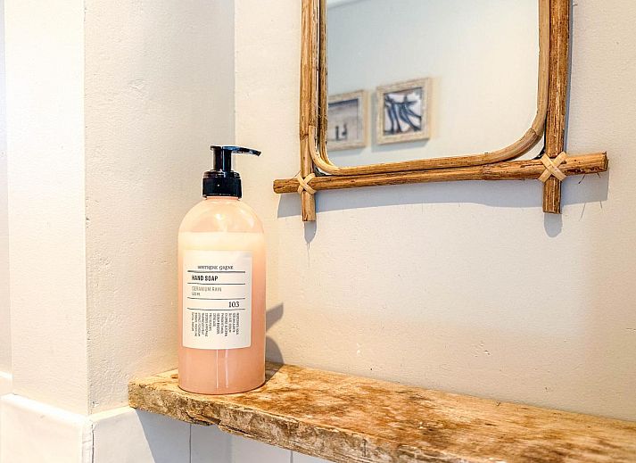 Stijlvolle woonkamer van vakantiehuis Sol in Callantsoog met veel natuurlijk licht.