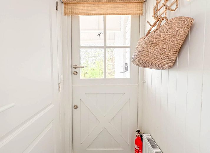 Stijlvolle woonkamer van vakantiehuis Sol in Callantsoog met veel natuurlijk licht.