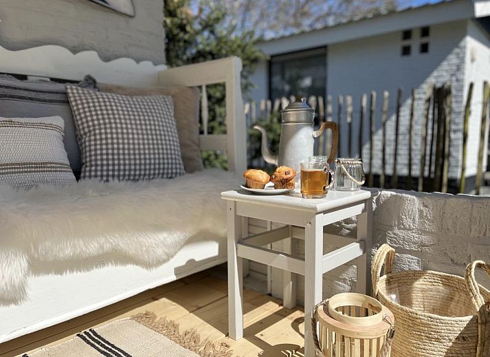 Stijlvolle woonkamer van vakantiehuis Sol in Callantsoog met veel natuurlijk licht.