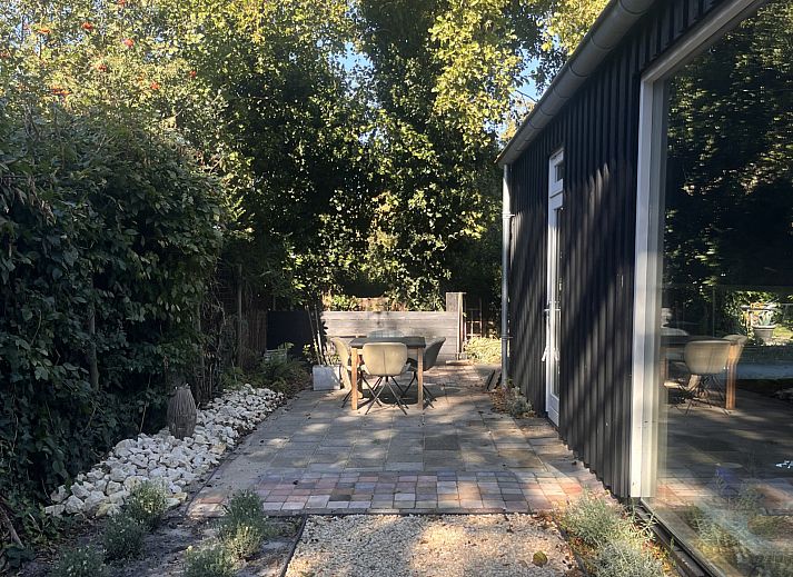 Ingang van vakantiehuis NH581 in Groet, Noordzeekust, Noord-Holland, met uitzicht op de tuin en een uitnodigende trap naar binnen.