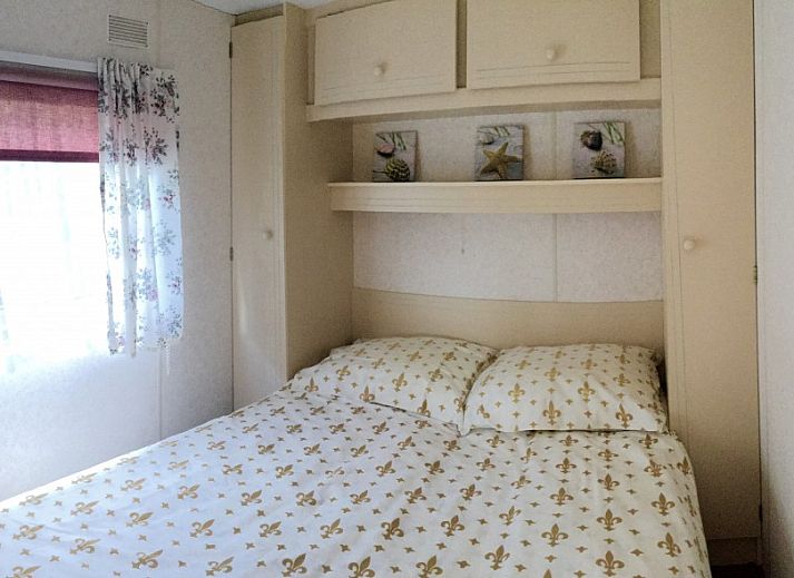 Ontspan op het zonnige terras van stacaravan De Zeemeeuw in Sint Maartenszee, Noordzeekust, Noord-Holland, omringd door groene natuur.