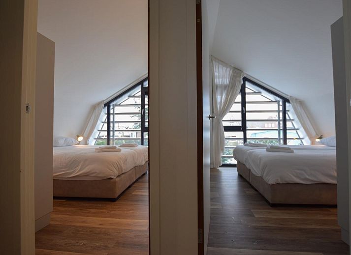 Gezellige woonkamer in vakantiehuis Duinland, Egmond aan den Hoef, met ruime zithoek en uitzicht op de groene omgeving aan de Noordzeekust.