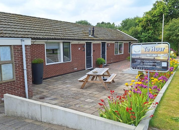 Vakantiehuisje in Egmond aan den Hoef met ruime patio en kleurrijke bloemen aan de Noordzeekust, Noord-Holland.