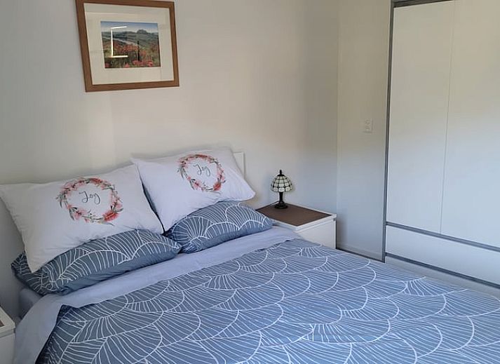 Picknicktafel op het terras van Vakantiehuisje in Egmond aan den Hoef, met uitzicht op bloeiende tuin, Noord-Holland.