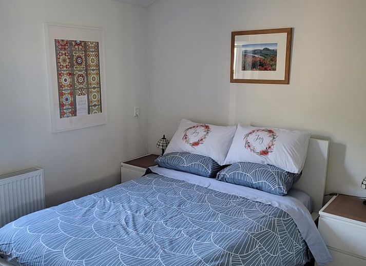 Picknicktafel op het terras van Vakantiehuisje in Egmond aan den Hoef, met uitzicht op bloeiende tuin, Noord-Holland.