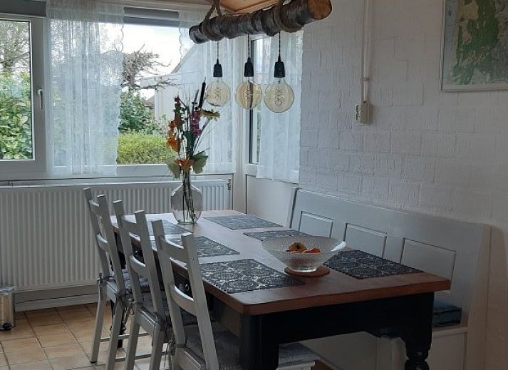 Veranda van vakantiehuis Rekere 111 in Schoorldam, Noordzeekust, Noord-Holland met zitgelegenheid en open deuren.