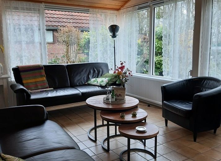 Veranda van vakantiehuis Rekere 111 in Schoorldam, Noordzeekust, Noord-Holland met zitgelegenheid en open deuren.