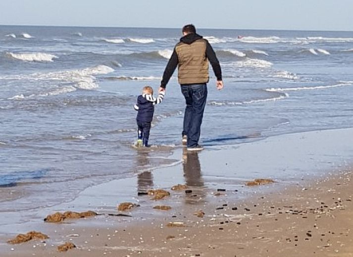 Eetkamer in vakantiehuis Rekere 111, Schoorldam, Noordzeekust, Noord-Holland met houten tafel en sfeervolle verlichting.