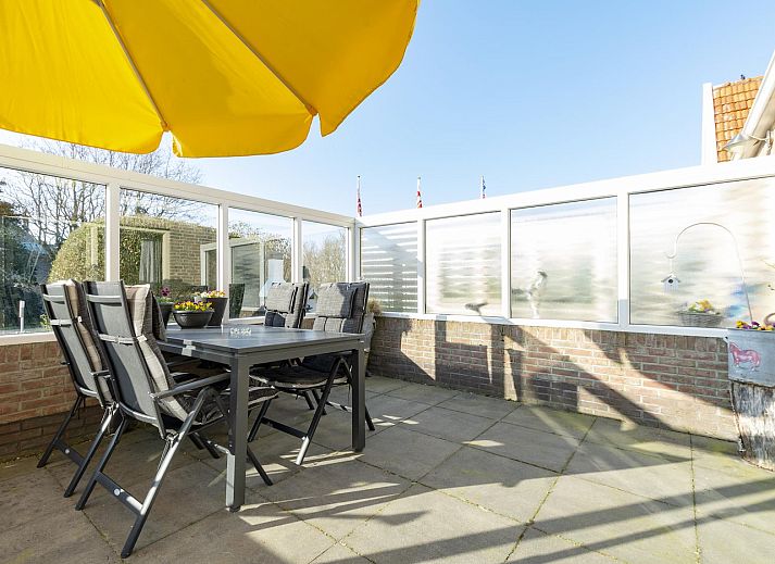 Terras met gele parasol bij Klaproos Groote Keeten vakantiewoning