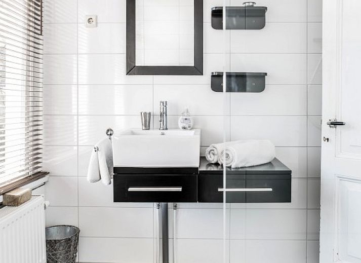 Cozy corner in Villa Beau Lieu, Bergen, with wooden nightstand and modern lamp next to comfortable bed.