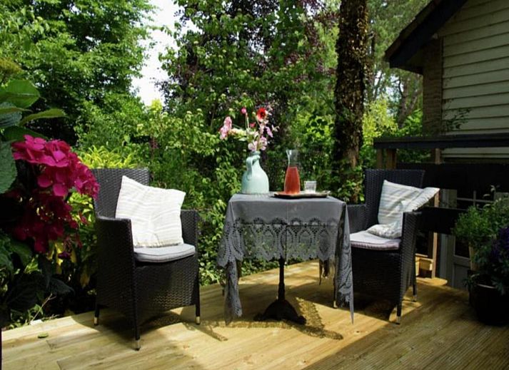 Geniet van de serene tuinveranda bij De Egelhut, een vakantiehuis aan de Noordzeekust in Bergen, Noord-Holland.