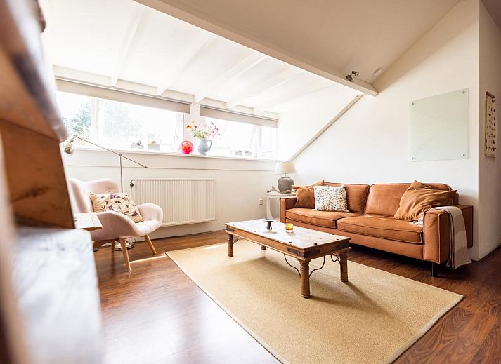 Gezellige binnenruimte van De Egelhut, een vakantiehuis in Bergen aan de Noordzeekust, Noord-Holland, met houten interieur en comfortabele zithoek.