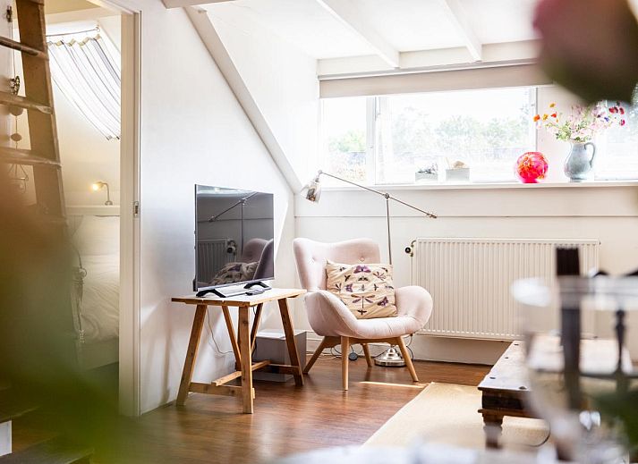 Gezellige binnenruimte van De Egelhut, een vakantiehuis in Bergen aan de Noordzeekust, Noord-Holland, met houten interieur en comfortabele zithoek.