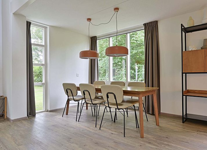 Terras van vakantiehuis in Julianadorp aan Zee met tuinmeubilair en parasol.