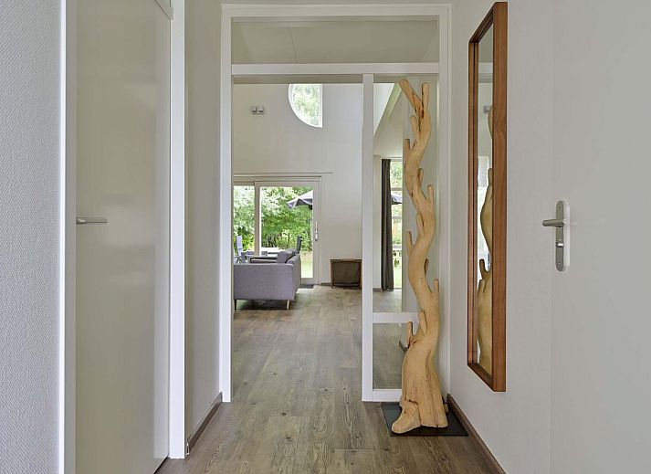 Terras van vakantiehuis in Julianadorp aan Zee met tuinmeubilair en parasol.