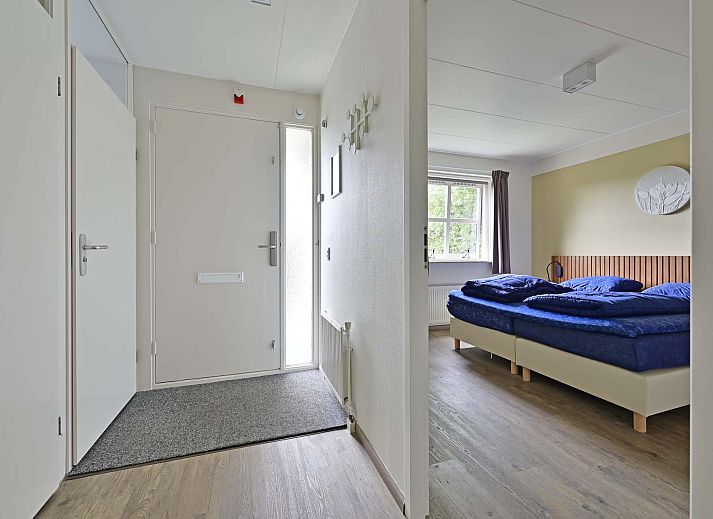 Terras van vakantiehuis in Julianadorp aan Zee met tuinmeubilair en parasol.