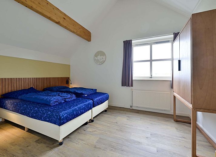 Ruime woonkamer met moderne inrichting in vakantiewoning Julianadorp aan Zee.