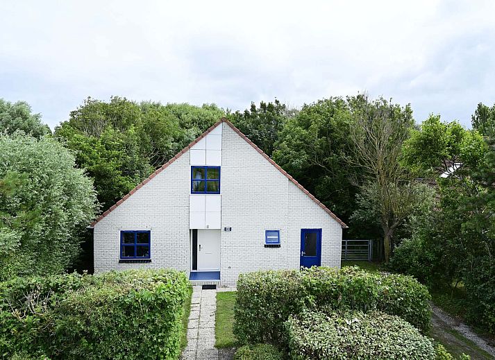 Gezellige zithoek met houten details in vakantiehuis Julianadorp aan Zee.