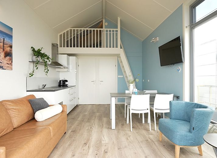 Geniet van het uitzicht op zee vanuit de lichte woonkamer van Beach House Comfort 4, een vakantiehuis in Julianadorp aan Zee, Noord-Holland.