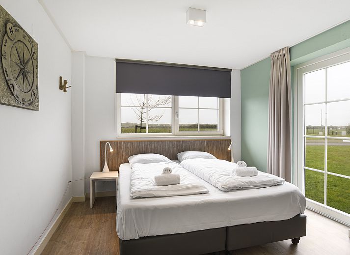 Comfortabele zithoek in Beach Resort Ooghduyne 16-persoons villa, Julianadorp aan Zee, met gezellige banken.