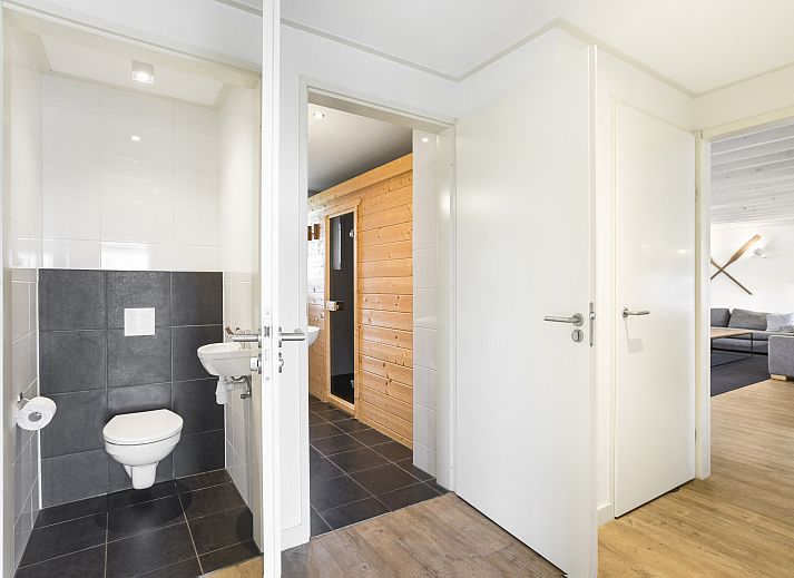 Comfortabele zithoek in Beach Resort Ooghduyne 16-persoons villa, Julianadorp aan Zee, met gezellige banken.