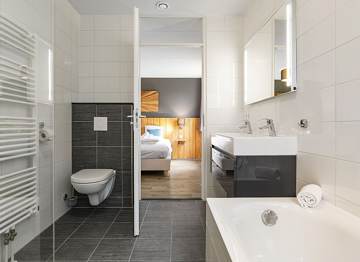 Comfortabele slaapkamer in Beach Resort Ooghduyne villa, Julianadorp aan Zee, met houten accenten.