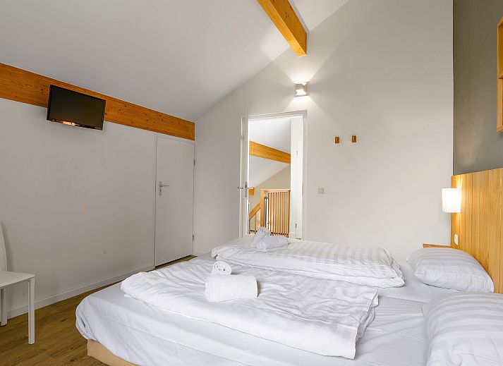 Comfortabele slaapkamer in Beach Resort Ooghduyne villa, Julianadorp aan Zee, met houten accenten.