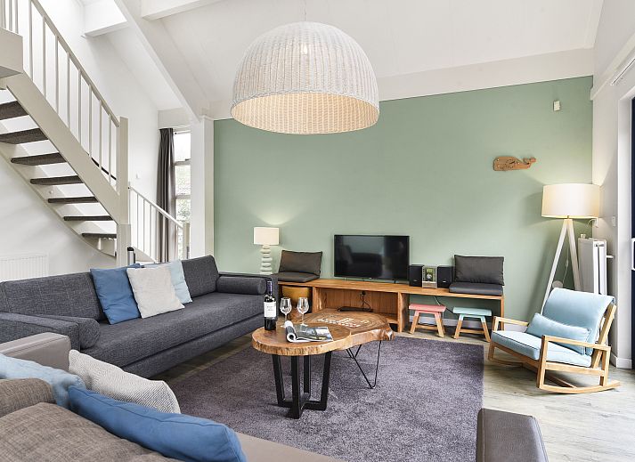 Gezellige woonkamer met uitzicht op tuin in Beach Resort Ooghduyne kindervilla, Julianadorp aan Zee.