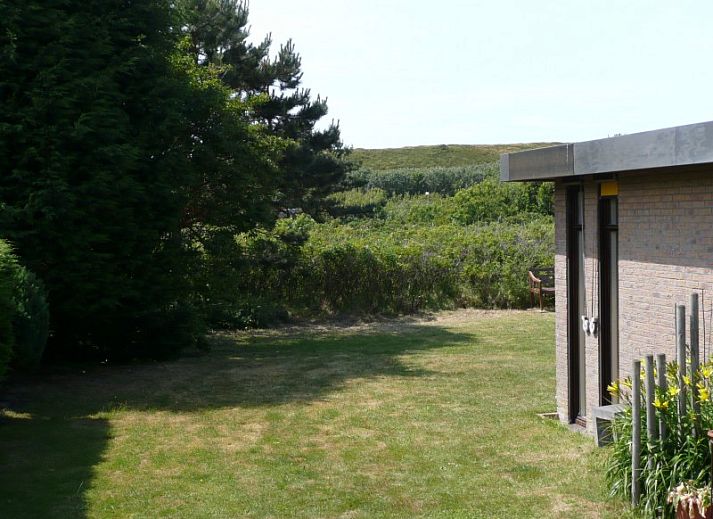 Rustiek bankje met uitzicht op natuur bij bungalow Duinzicht in Julianadorp aan Zee, Noord-Holland.