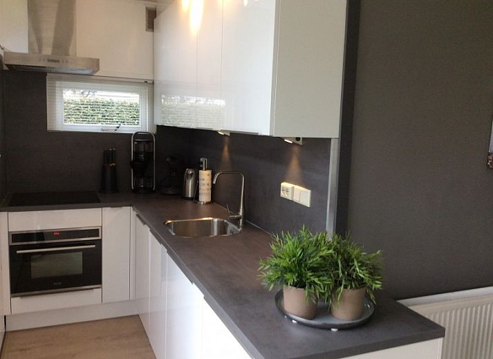 Rustiek bankje met uitzicht op natuur bij bungalow Duinzicht in Julianadorp aan Zee, Noord-Holland.