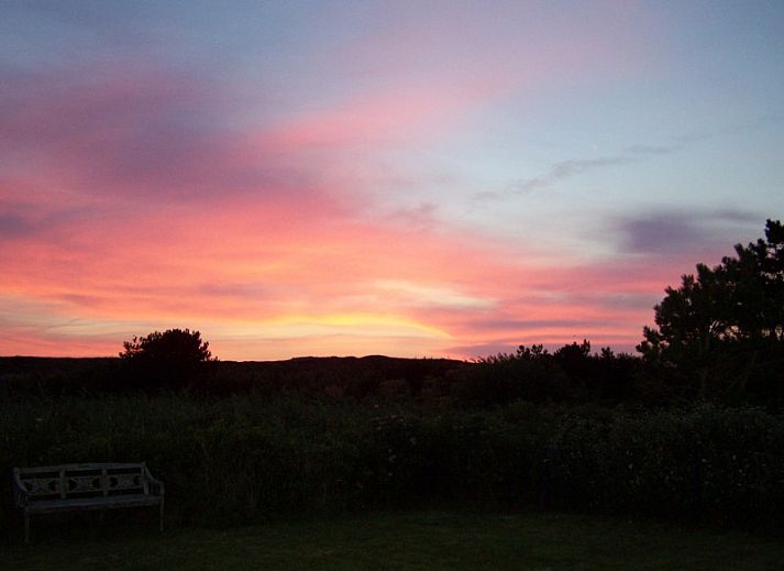 Groene tuin en zijaanzicht van bungalow Duinzicht aan de Noordzeekust, Julianadorp aan Zee.