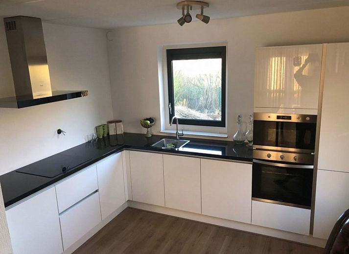 Huis op Duynopgangh in Julianadorp, een charmant vakantiehuis aan de Noordzeekust met rieten dak en zonnig terras.